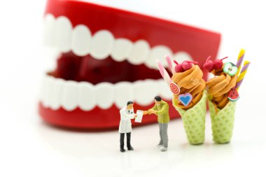 Minyatür insanlar: diş hekimi ve diş hasta ve tatlı dondurma ile sağlık tıbbi kavramı önünde sağlık ekibi.