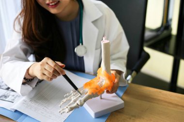 Doktor omurga diz eklemi yerleşimini bir kemik üzerinde işaret ediyor