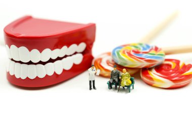 Minyatür insanlar: bir hastanın diş inceleyerek hasta ve tatlı lolipop, sağlık tıbbi kavramı ile diş hekimi.