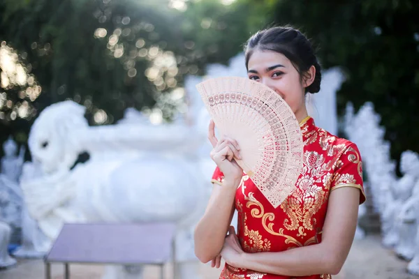 Güzel Asyalı bir kadın portresi tutun şans para ve kırmızı cep, Çin yeni yılı konsept.