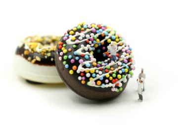 Minyatür insanlar: Chef sunmaktadır renkli sprinkles ile bir çörek tatlı