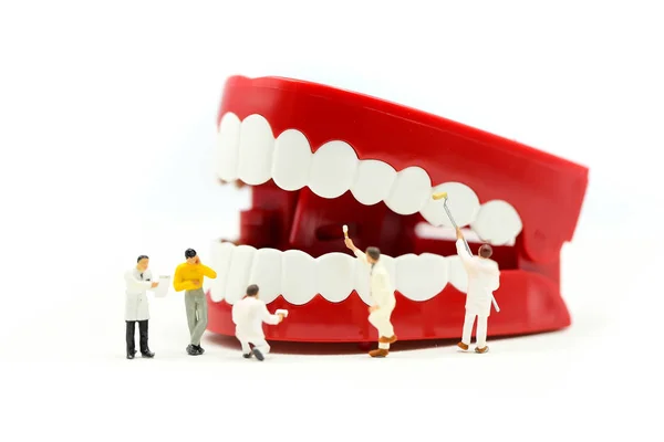 Minyatür insanlar: temiz diş ya da diş dişçi günü kavramını kullanan bir hastanın dişleri, inceleyerek dişçi modeliyle.