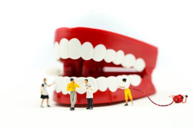 Minyatür insanlar: temiz diş ya da diş dişçi günü kavramını kullanan bir hastanın dişleri, inceleyerek dişçi modeliyle.