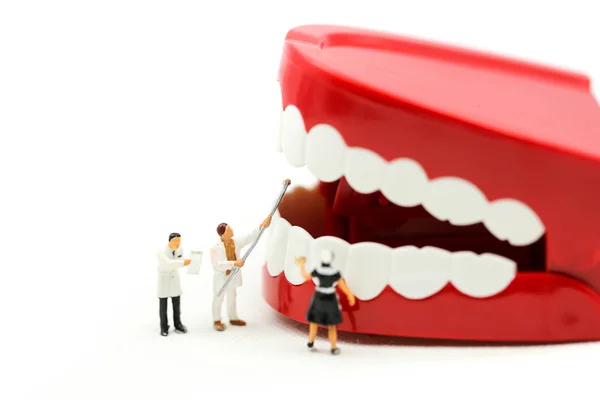 Minyatür insanlar: temiz diş ya da diş dişçi günü kavramını kullanan bir hastanın dişleri, inceleyerek dişçi modeliyle.