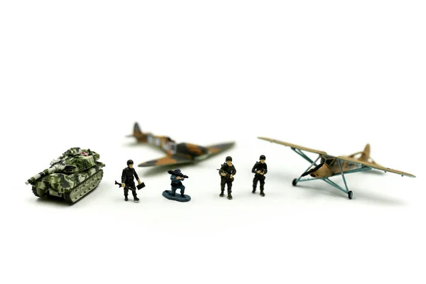 Miniature people : team soldier standing together with army tank and aircraft air combat using for Toy Soldier Day concept.