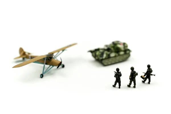 Miniature people : team soldier standing together with army tank and aircraft air combat using for Toy Soldier Day concept.