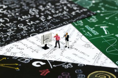 Minyatür insanlar: öğretmen ve grafik kağıt üzerinde formül dünya matematik günü kavramı için kullanarak aritmetik matematik problemleri ile arkadaş.