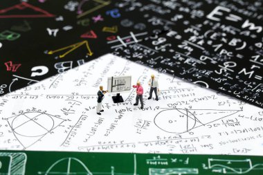 Minyatür insanlar: öğretmen ve grafik kağıt üzerinde formül dünya matematik günü kavramı için kullanarak aritmetik matematik problemleri ile arkadaş.