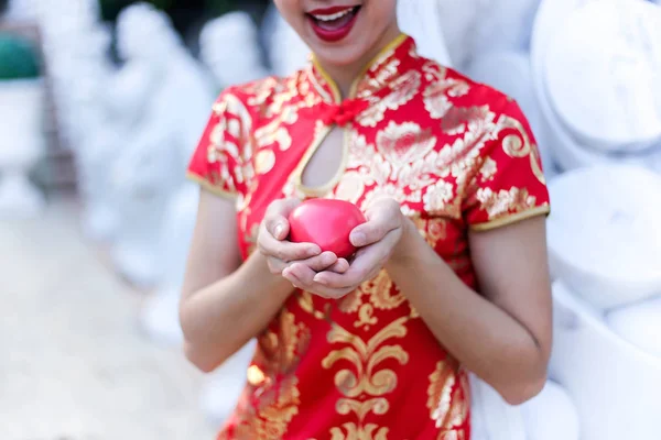 Bella ragazza asiatica che indossa Cheongsam vestito rosso mano tenendo re — Foto Stock