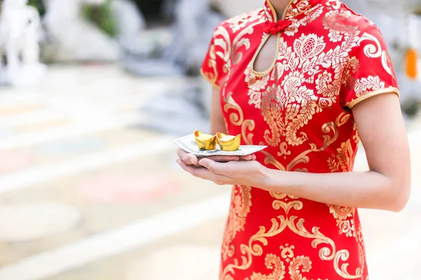 Schöne asiatische Mädchen tragen Cheongsam rotes Kleid hält Gold b — Stockfoto