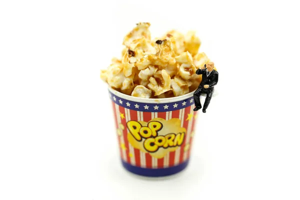 Miniaturmenschen: Menschen mit Karamell-Popcorn entspannen — Stockfoto