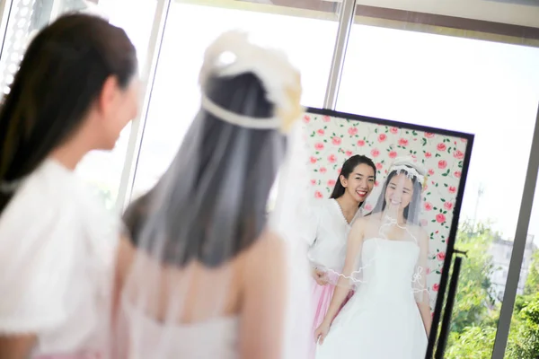 Beautiful bride getting dressed by her best friend in her weddin