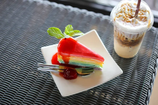 Gâteau en crêpe coloré arc-en-ciel avec sauce aux fraises et roche froide — Photo
