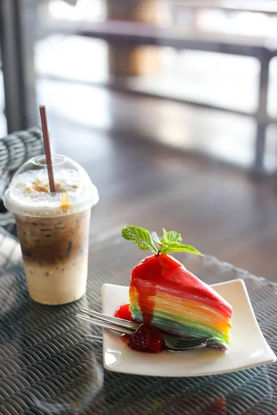 Gâteau en crêpe coloré arc-en-ciel avec sauce aux fraises et roche froide — Photo