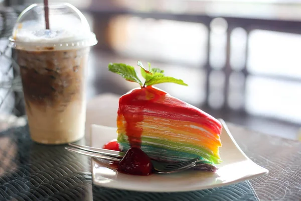 Gâteau en crêpe coloré arc-en-ciel avec sauce aux fraises et roche froide — Photo