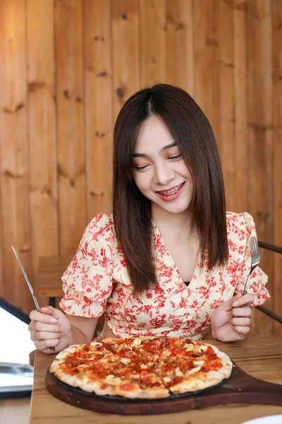 Belle jeune asiatique femme manger délicieux ou délicieux pizza . — Photo