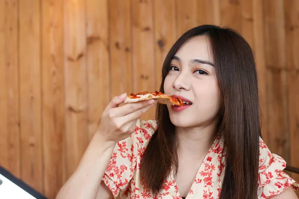 Bela jovem asiático mulher comer delicioso ou gostoso pizza . — Fotografia de Stock
