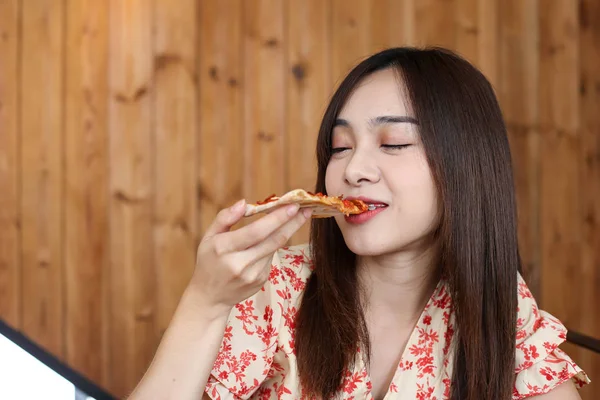 Belle jeune asiatique femme manger délicieux ou délicieux pizza . — Photo