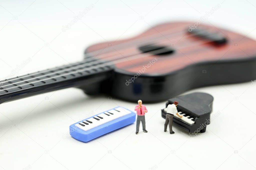 Miniature people : man play mini piano with  sitting on acoustic