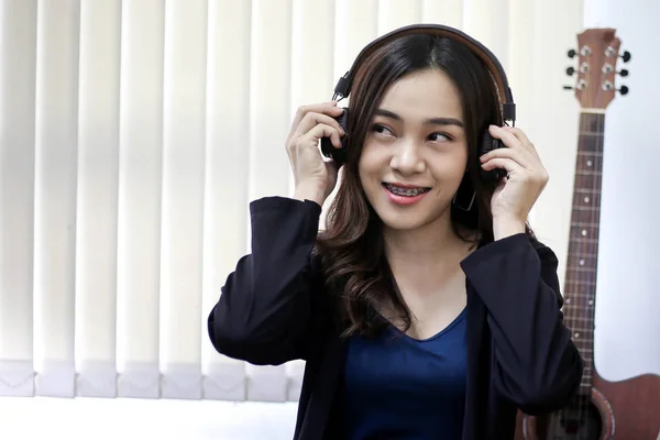 Досить красива азіатська жінка в навушниках і прослуховування мс — стокове фото
