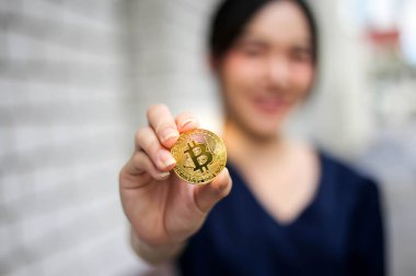 Bitcoin altın c tutan İş kadını ile odak seçici