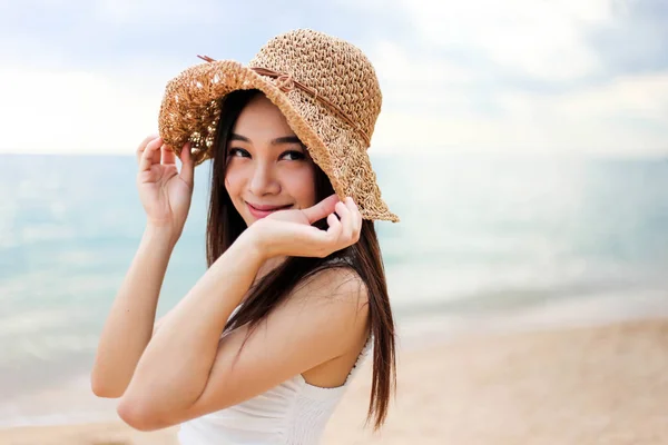Menina bonita jovem mulher asiática em um chapéu sorrindo na praia um — Fotografia de Stock