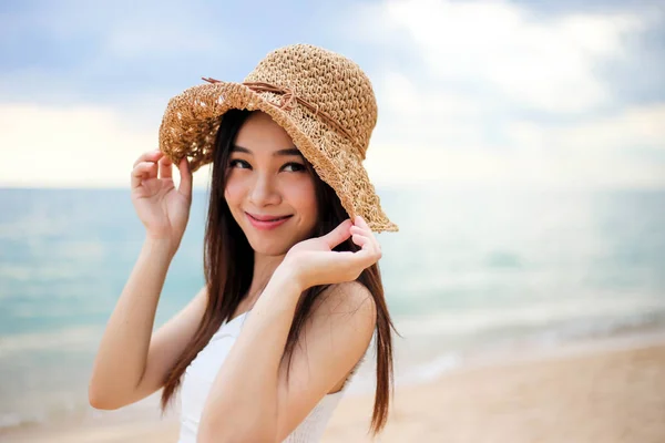 Menina bonita jovem mulher asiática em um chapéu sorrindo na praia um — Fotografia de Stock