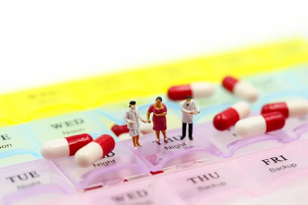 Minyatür insanlar: Doktor, hasta ilaçlarını İlaç Kutusu ve Günlük Tıp ile gösteriyor