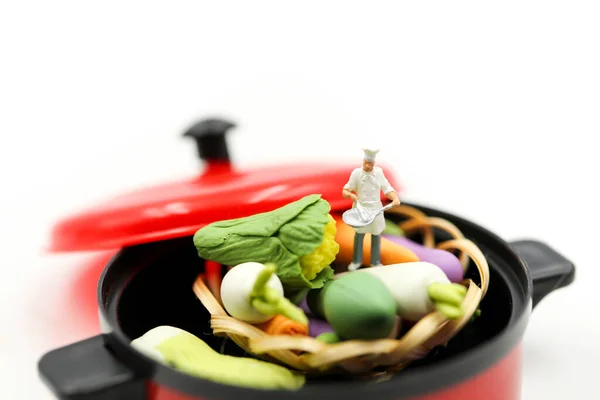 小人物 厨师在锅里煮新鲜蔬菜 免版税图库图片