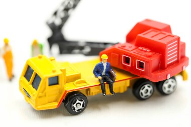 Minyatür insanlar: Kazıcı traktörlü bir inşaat sahasında çalışan işçi ve mühendis grubu