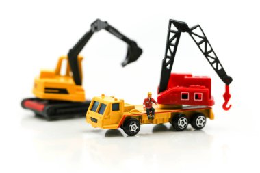 Minyatür insanlar: Kazıcı traktörlü bir inşaat sahasında çalışan işçi ve mühendis grubu