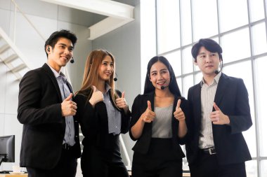 Asya Çağrı Merkezi çalışanlarından oluşan bir grup veya ofiste kulaklığı olan kendine güvenen iş adamları.