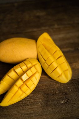 Tropikal meyveler: Ahşap arka planda çeşitli mangolar. Doğal ışıklandırma