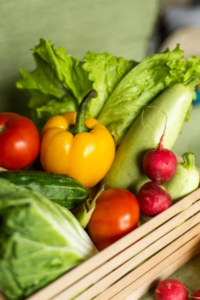 Фрукты и овощи в деревянной коробке на зеленом фоне. — стоковое фото