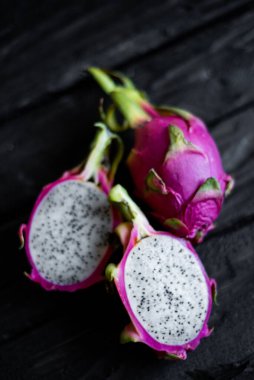 Ahşap bir arka planda izole edilmiş egzotik ejderha meyvelerinin yakın görüntüsü. Taze vejetaryenler vitaminli lezzetli yiyecekler. Yaz tatili meyvelerinin güzel resmi