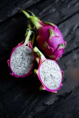 Ahşap bir arka planda izole edilmiş egzotik ejderha meyvelerinin yakın görüntüsü. Taze vejetaryenler vitaminli lezzetli yiyecekler. Yaz tatili meyvelerinin güzel resmi