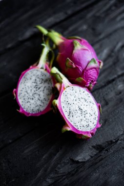 Ahşap bir arka planda izole edilmiş egzotik ejderha meyvelerinin yakın görüntüsü. Taze vejetaryenler vitaminli lezzetli yiyecekler. Yaz tatili meyvelerinin güzel resmi