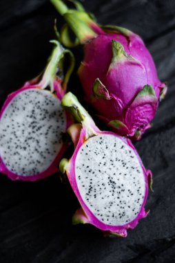 Ahşap bir arka planda izole edilmiş egzotik ejderha meyvelerinin yakın görüntüsü. Taze vejetaryenler vitaminli lezzetli yiyecekler. Yaz tatili meyvelerinin güzel resmi