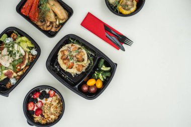 Beyaz arka planda sağlıklı yiyeceklerle dolu kutular vardı. Restoran yemekleri. Düz yatıyordu