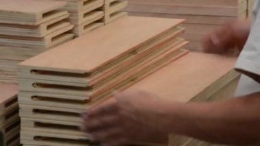 Calidad 'ı kontrol et, Masaras' ı kontrol et. Trabajador revisando piezas de madera