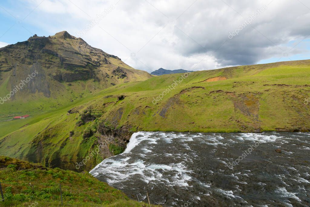 river cascade on high plateau in front of Skogafoss waterfall on
