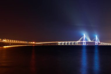 Incheon köprü gece sahne. Çeşitli renklerin Incheon köprü gece görünümü. Denizin üzerine düşünceler. Incheon Havaalanı Incheon köprüye. Kore Cumhuriyeti.