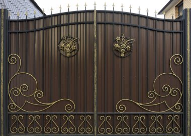 Süslü ve güzel ferforje çit kapısı kırmızı kahverengi ve altın boyalı