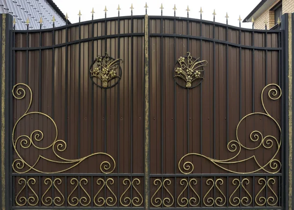 Süslü ve güzel ferforje çit kapısı kırmızı kahverengi ve altın boyalı