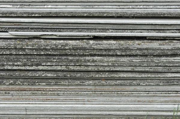 Kiremit çatı ev yapımında kullanılmak üzere yığılmış. İnşaat asbest-çimento levhalar. Seramik desen arka plan yığını