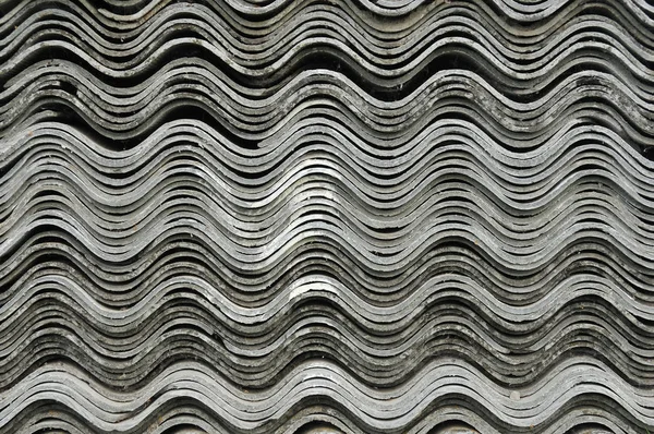 Kiremit çatı ev yapımında kullanılmak üzere yığılmış. İnşaat asbest-çimento levhalar. Seramik desen arka plan yığını