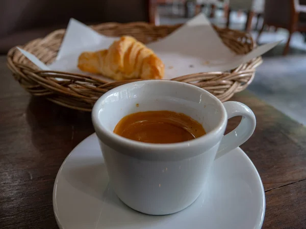 Cafe espresso, Tik ahşap masada Cafe espresso Croissant, kahvaltı konsepti.