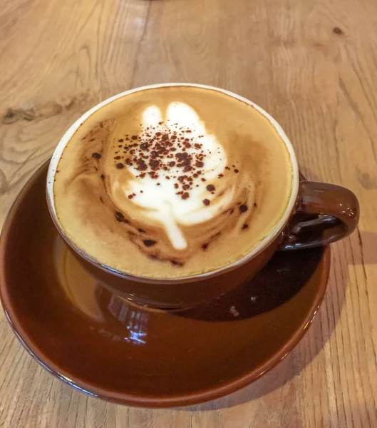 Latte sanat kahve. Bir fincan kahve. Köpüklü Cuppucino, sütlü kahve, Espresso kahve içecek fincan. Latte sanat ahşap arka plan üzerinde kahve. Kahve espresso ve haşlanmış süt ile yapılan bir kahve içecektir.