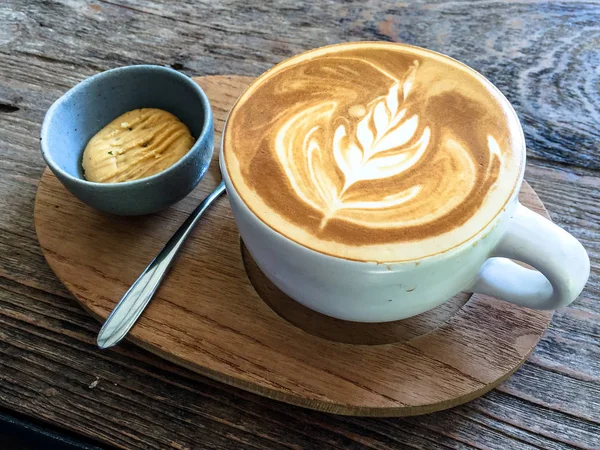 Latte sanat kahve. Bir fincan kahve. Köpüklü Cuppucino, sütlü kahve, Espresso kahve içecek fincan. Latte sanat ahşap arka plan üzerinde kahve. Kahve espresso ve haşlanmış süt ile yapılan bir kahve içecektir.