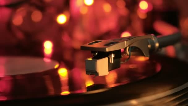 Close up of vinyl turntable record player rotating disc. Multicolored light. — Stock Video